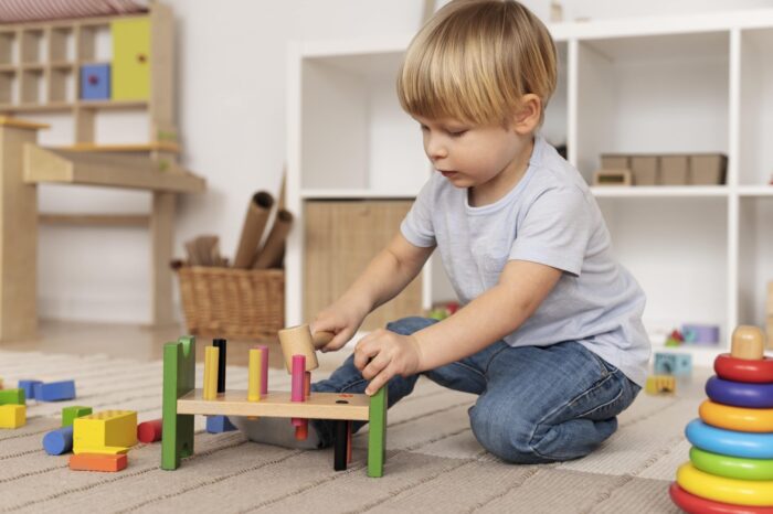 gioco montessori: bambino che gioca con gioco di legno