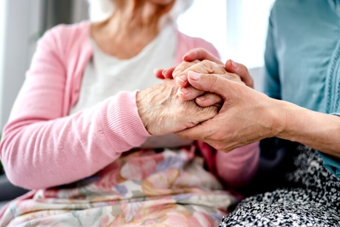 scatti di anzianità: anziana e badante che si stringono la mano